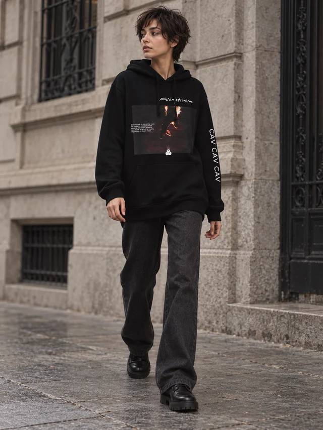 Full-body street editorial: the same model wearing the original black consumptionism hoodie in a new street setting